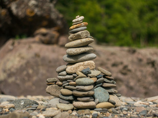 Fototapeta na wymiar pyramid of stones on the river Bank