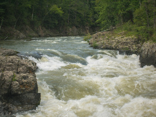 Mountain rapid river with rocky shores threshold