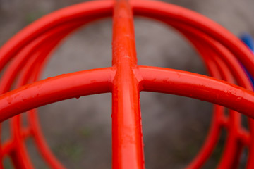 Red pipes in the playground close-up in raindrops