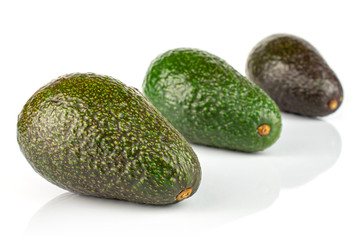 Group of three whole fresh green avocado placed diagonally isolated on white background