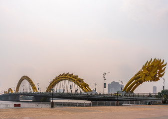 Da Nang, Vietnam - March 10, 2019: Tail end of Cau Rong or Dragon bridge over Han River under morning sky. Some high rise buildings farther away.