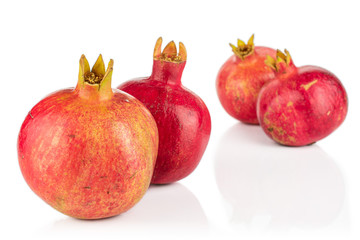 Group of four whole fresh red pomegranate isolated on white background
