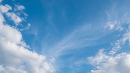 Blue sky with white clouds and little moon for text background.