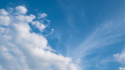 Blue sky with white clouds and little moon for text background.
