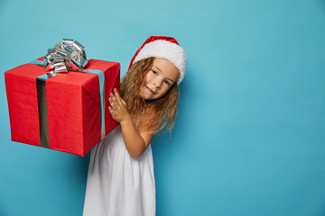  Girl in Santa red hat holding Christmas gift