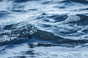 Beautiful   blue sea water surface with low waves. Seascape background. Calm Dark Sea Waves. Close-up, shallow focus.