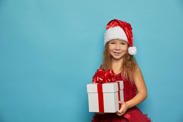  Girl in Santa red hat holding Christmas gift