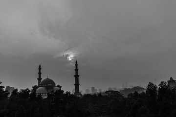 Sunrise over silhouette mosque and hazy