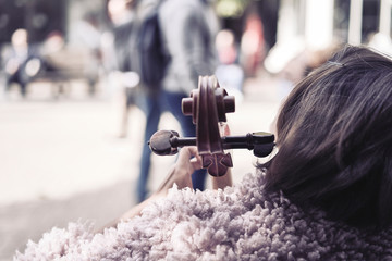 Musician woman playing cello in the street