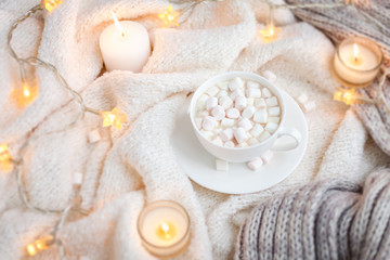 Warm knitted blanket, cup of coffee, marshmallows, Christmas lights, vintage toy, candles
