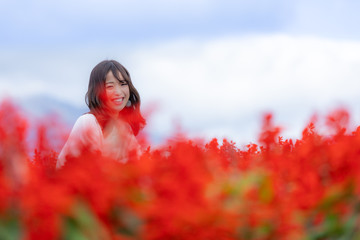 女性　花畑　赤　正面　笑顔　コピースペース 