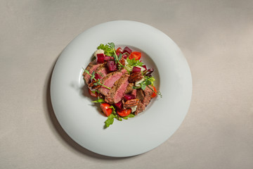 Beef steak salad served in white plate
