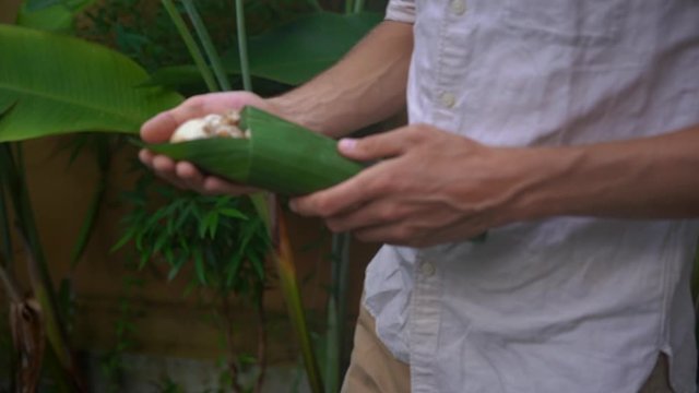 Eco-friendly product packaging concept. Vegetables wrapped in a banana leaf, as an alternative to a plastic bag. Zero waste concept. Alternative packaging