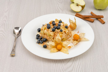 Baked apple slices with cottage cheese on a white plate on the table
