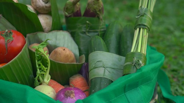 Eco-friendly product packaging concept. Vegetables wrapped in a banana leaf, as an alternative to a plastic bag. Zero waste concept. Alternative packaging