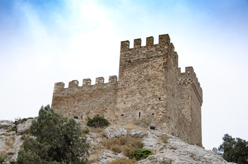 Fototapeta na wymiar Tower of an old medieval fortress in the mountains.