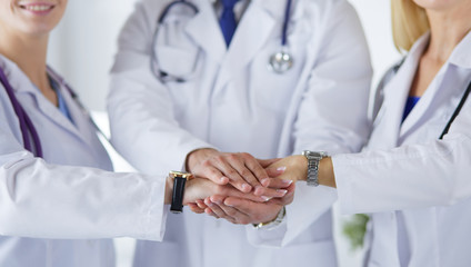 Doctors and nurses in a medical team stacking hands