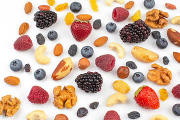 Different fresh berries and nuts on a white background. Vitamin and healthy food.