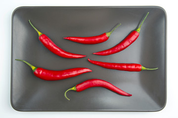 Red hot pepper close up on a grey plate Healthy vegetable food and vitamins.