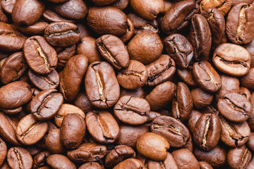 Naklejka premium Coffee beans texture. Morning energy roasted brown beans background.