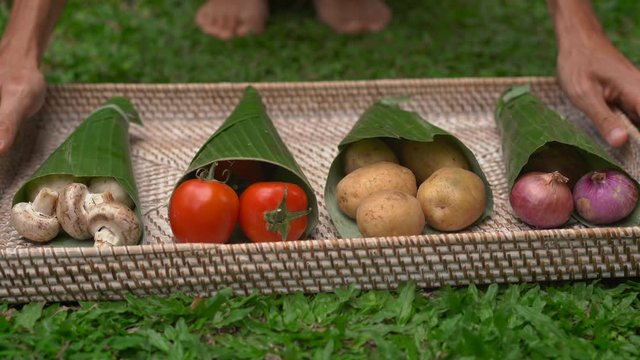 Eco-friendly product packaging concept. Vegetables wrapped in a banana leaf, as an alternative to a plastic bag. Zero waste concept. Alternative packaging