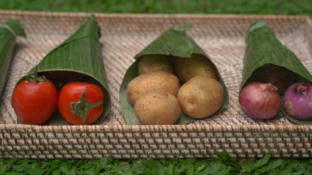 Eco-friendly product packaging concept. Vegetables wrapped in a banana leaf, as an alternative to a plastic bag. Zero waste concept. Alternative packaging