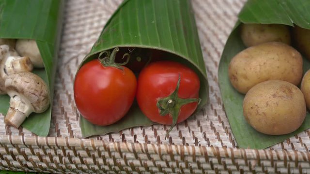 Eco-friendly product packaging concept. Vegetables wrapped in a banana leaf, as an alternative to a plastic bag. Zero waste concept. Alternative packaging