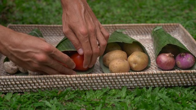 Eco-friendly product packaging concept. Vegetables wrapped in a banana leaf, as an alternative to a plastic bag. Zero waste concept. Alternative packaging