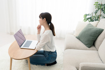 部屋でインターネットをする女性