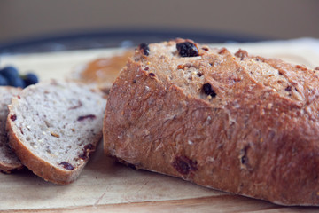 Focus on the outer crust of a home baked loaf of whole grain sliced bread on the counter top