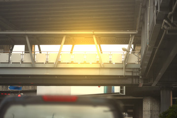 walking bridge or flyover or overpass at street with sun flare