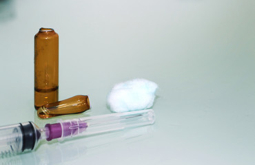medical syringe ,alcohol cotton ball and cracked ampule in treatment concept