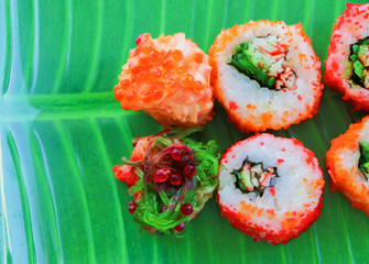 Sushi on a tray of green food