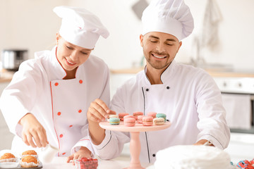 Young confectioners cooking tasty dessert in kitchen