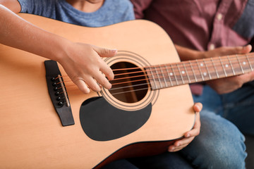 Fototapeta premium Little boy playing guitar at home, closeup