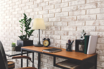 Modern stylish workplace near brick wall