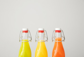 Bottles of fresh juices on grey background