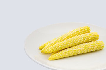 Baby corn in dish on white background.