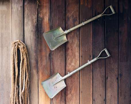 Shovel on old wooden wall background.