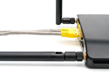 Black wireless router with local area network cable isolated on white background