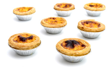 egg tart in aluminum foil cup isolated on white background