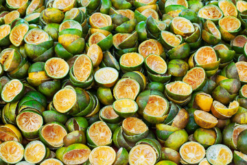 Green cut tangerine peels rings texture background close up, many fresh squeezed orange mandirins...
