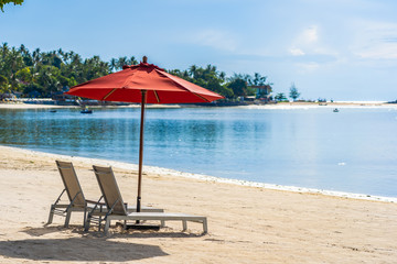 Beautiful outdoor tropical beach sea ocean with umbrella chair and lounge deck around there on white cloud blue sky