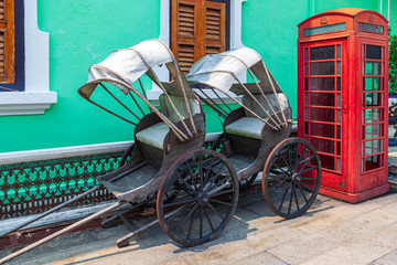 Traditional horse carriage & red telephone box inside the courtyard of a Baba Nyonyas period home in George Town, Penang, Malaysia