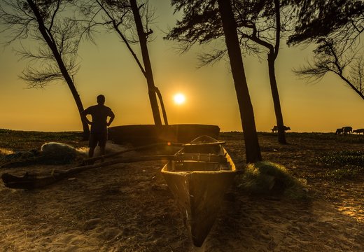 silhouette of a man standing and looking at evening sun, Pollem, Goa, India