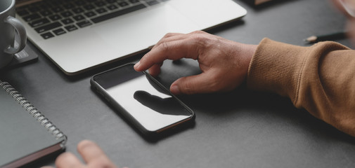 Cropped shot of man using his smartphone while working the project