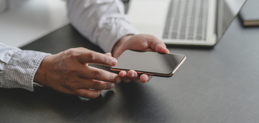 Close-up view of businessman looking for information on smartphone