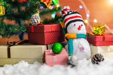 Snowman for decorating with Christmas tree with colorful gift boxes on snow ground for Christmas holiday celebration