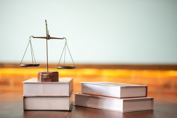 A close up of legal books with justice on the courtroom table