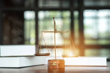 A close up of legal books with justice on the courtroom table